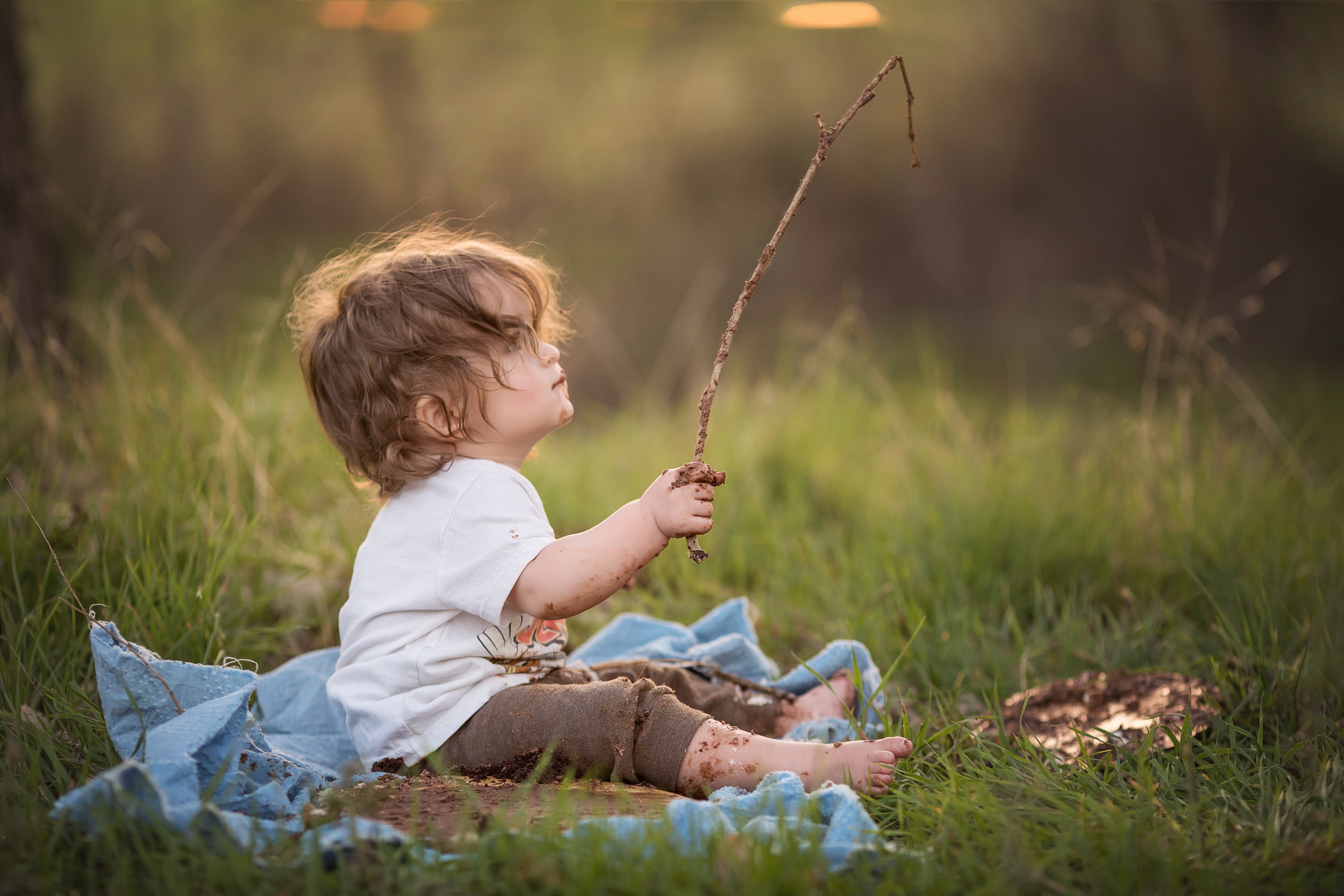Little boy with messy hair playing with a stick at sunset photographed by Los Angeles children's photographer A Pocket of Time Photography