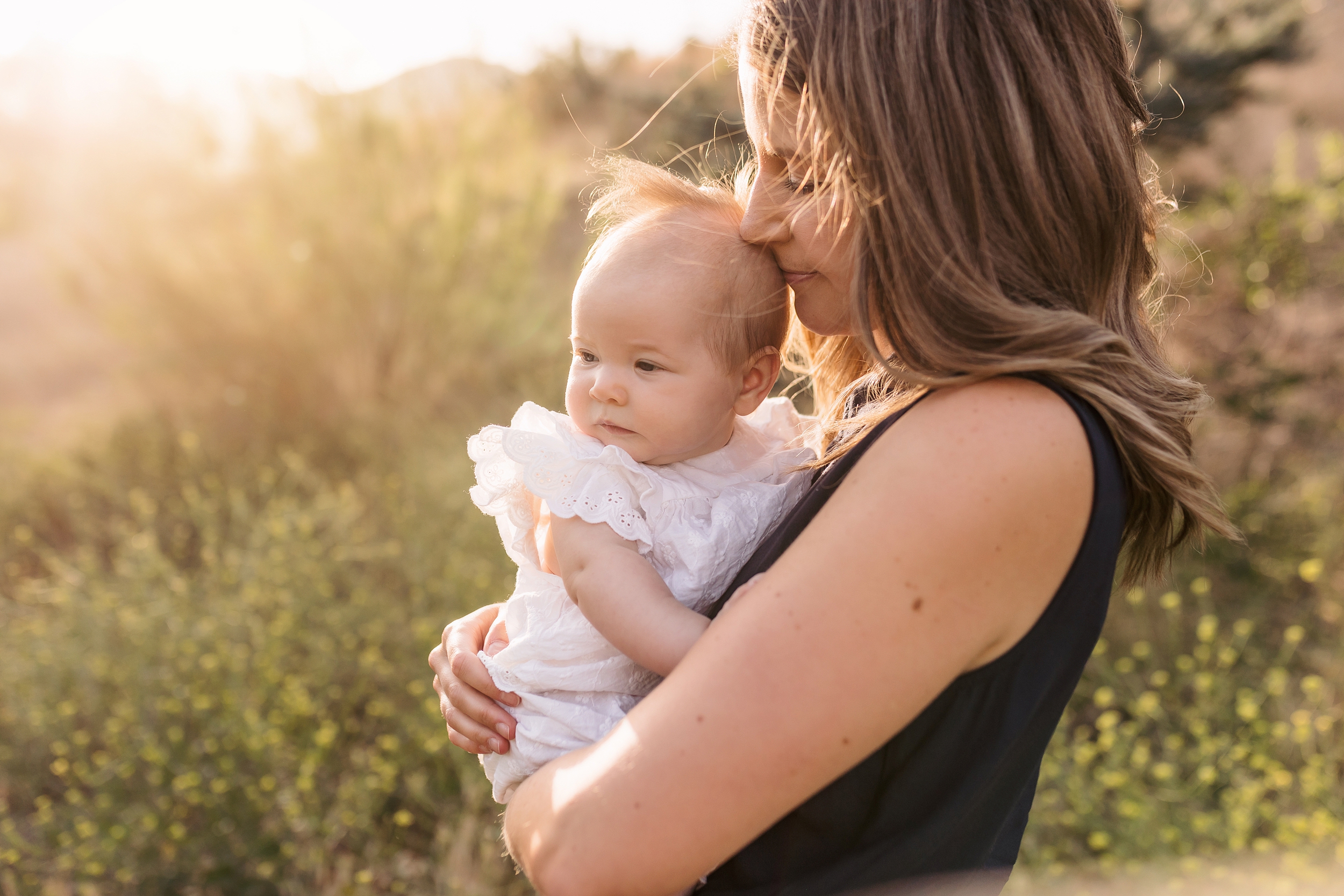 Mom kissing her baby girl outdoors at sunset in Granada Hills by family photographer A Pocket of Time Photography